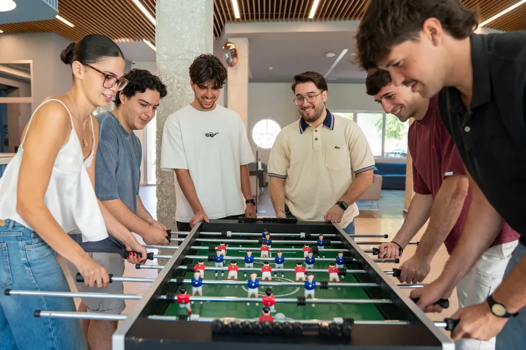 Estudiantes jugando al futbolín en la zona de ocio